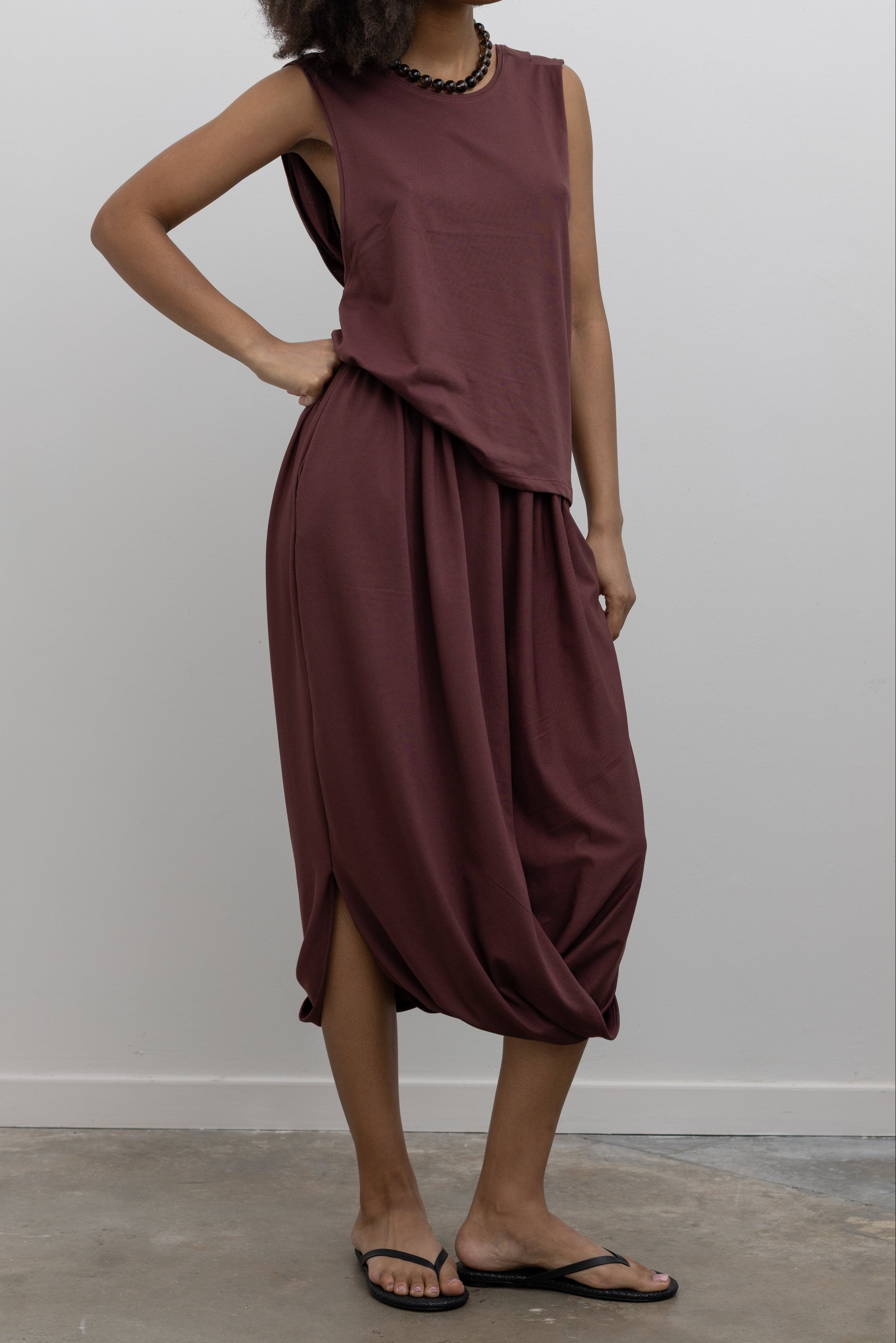 Collective fluid cotton-blend midi skirt featuring a cocoon silhouette and side pockets at Alas Eius