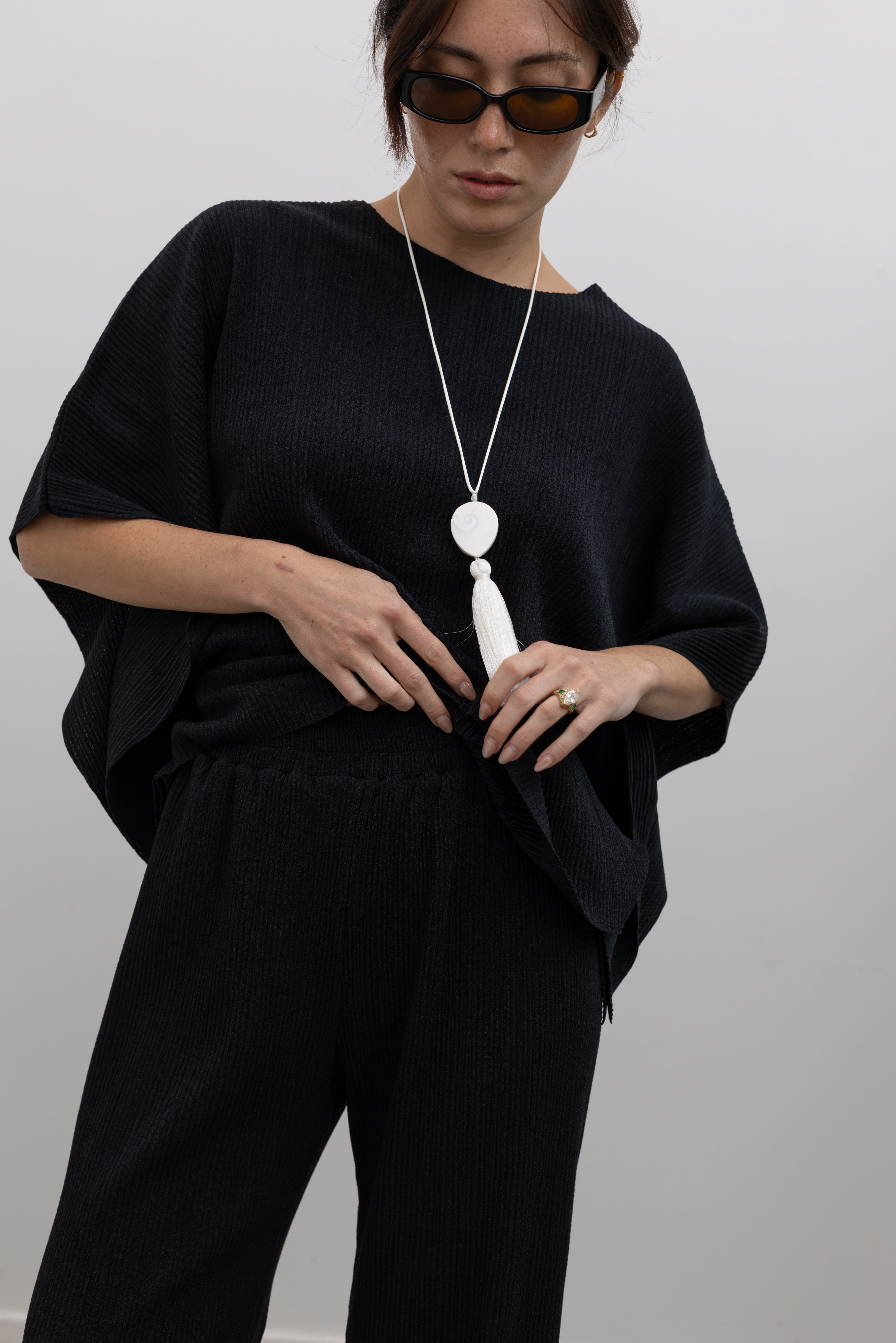 Collective fluid pleated trousers featuring an elastic waistband and effortless drape at Alas Eius