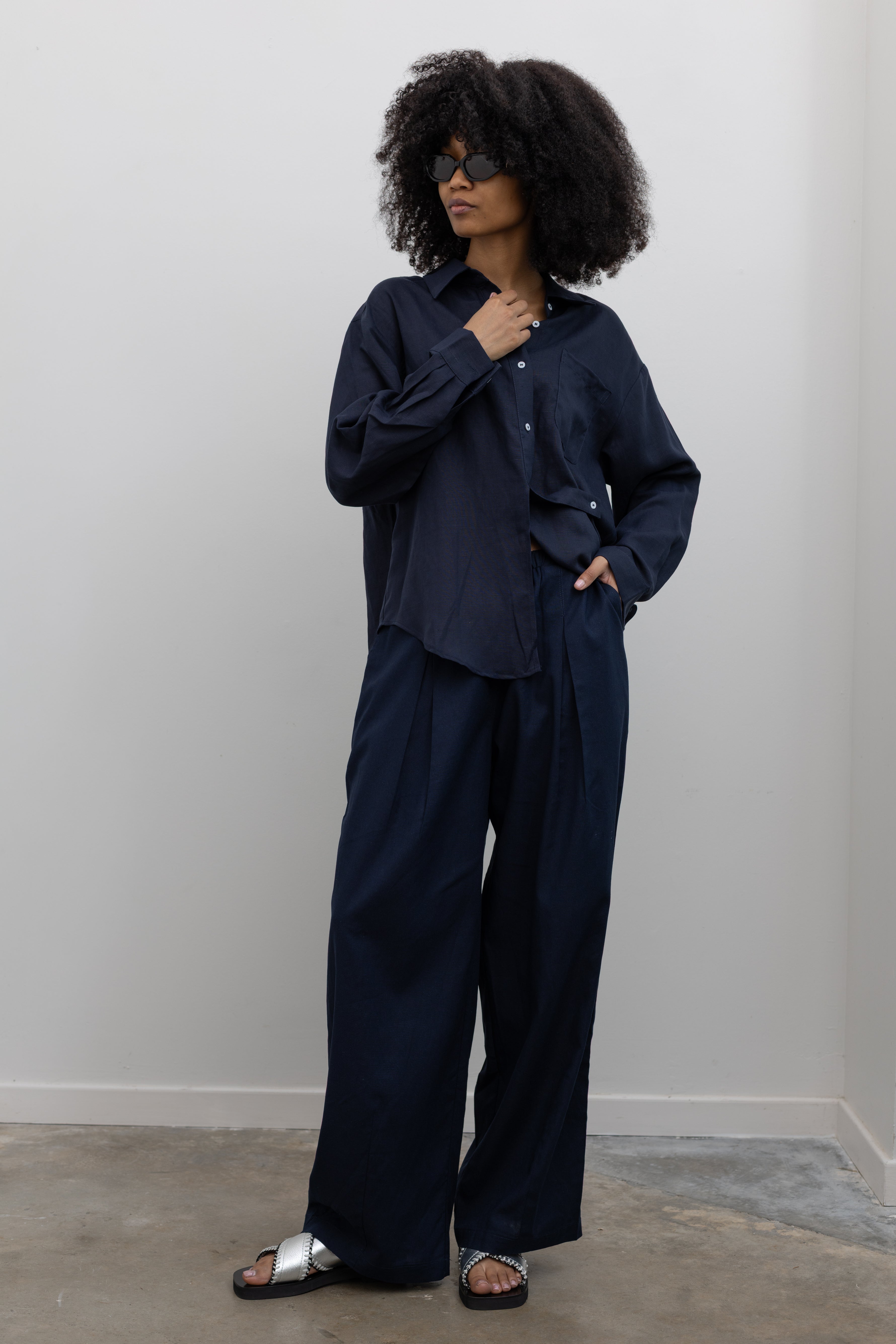 Collective wide-leg Ink Linen Tuck Pants styled with a relaxed button-down shirt at Alas Eius