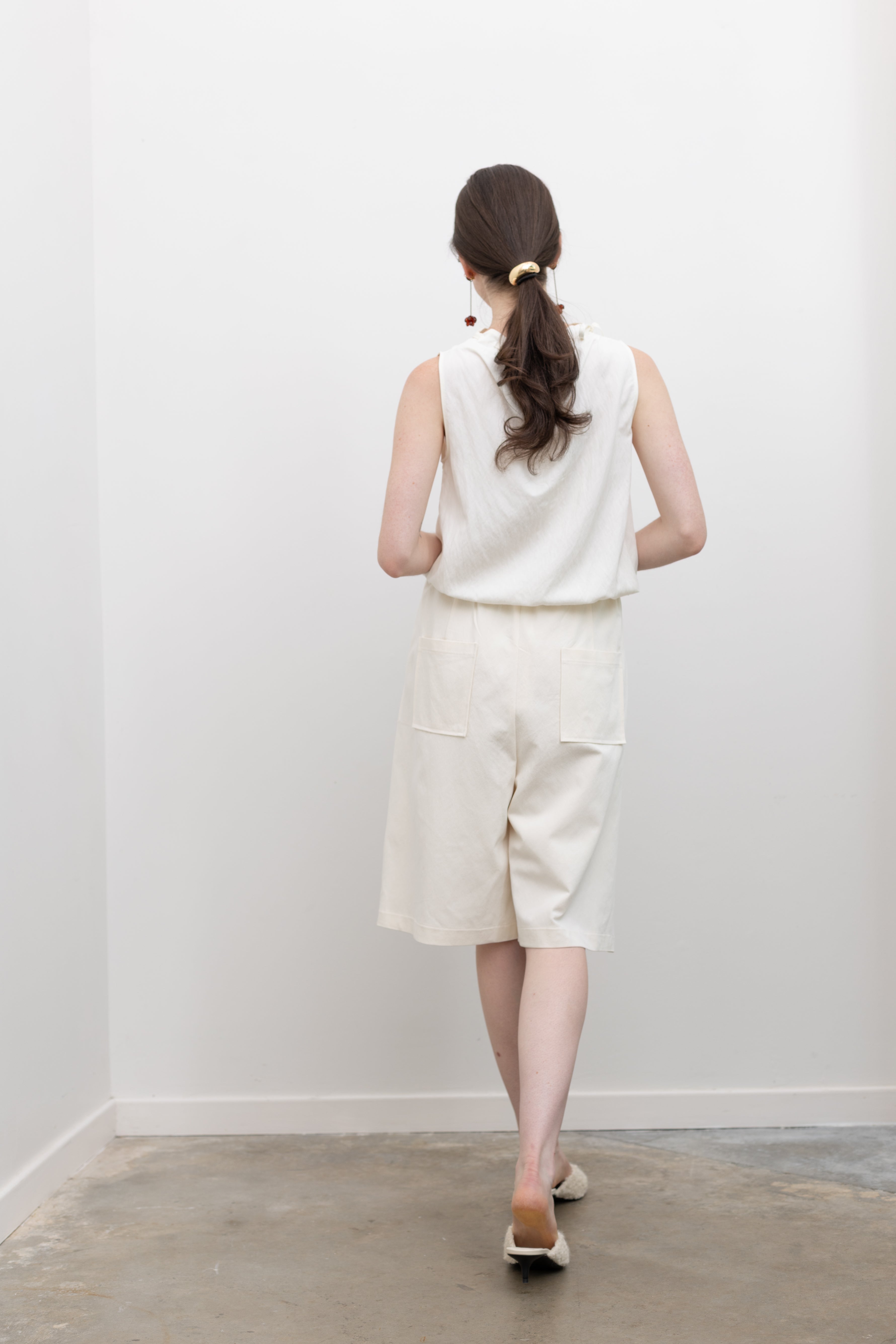 Collective mock neck sleeveless blouse with sculpted waist bubble hem, designed for women's chic workwear and refined styling at Alas Eius