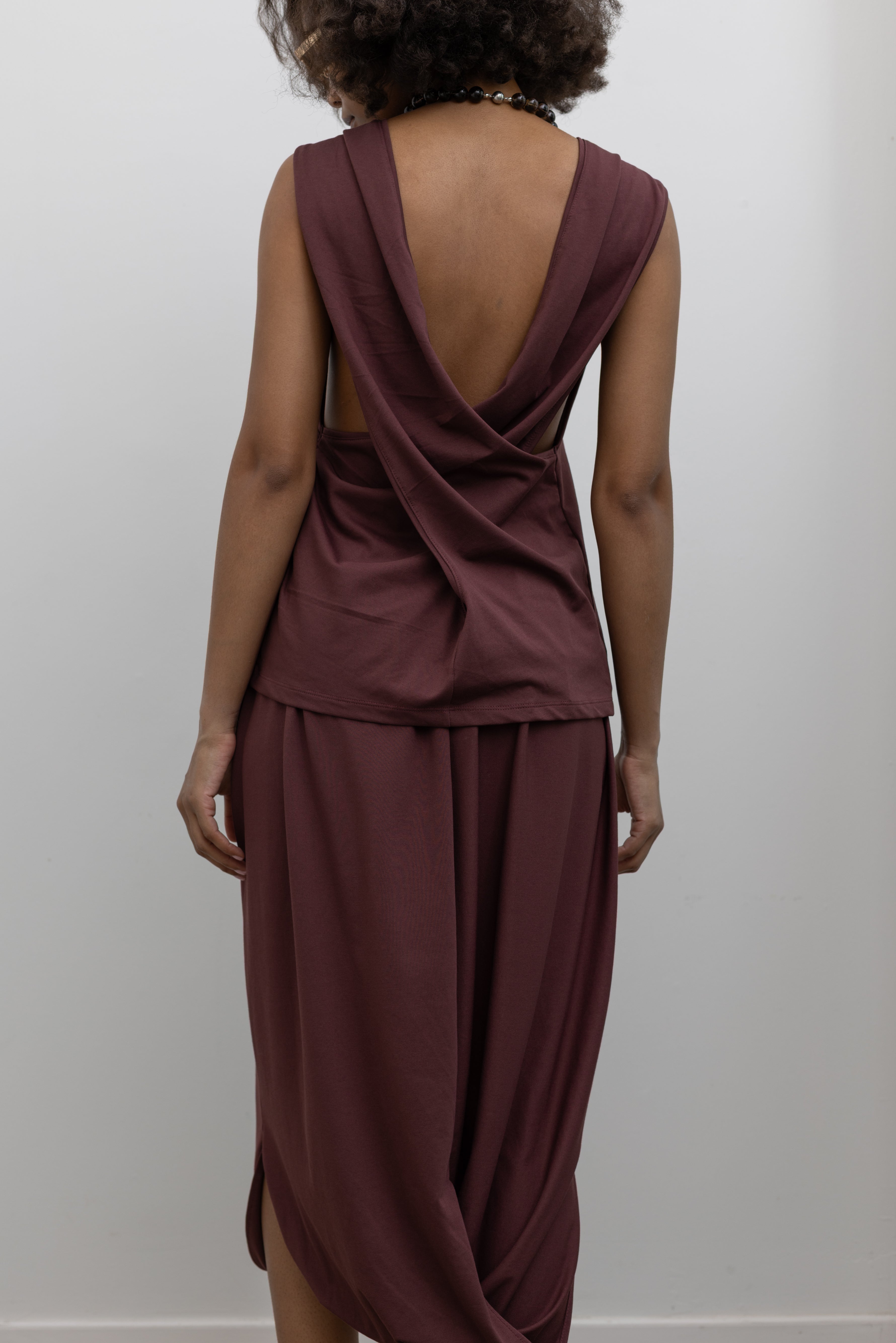 Collective modern sleeveless crewneck top with elegant cowl back silhouette at Alas Eius