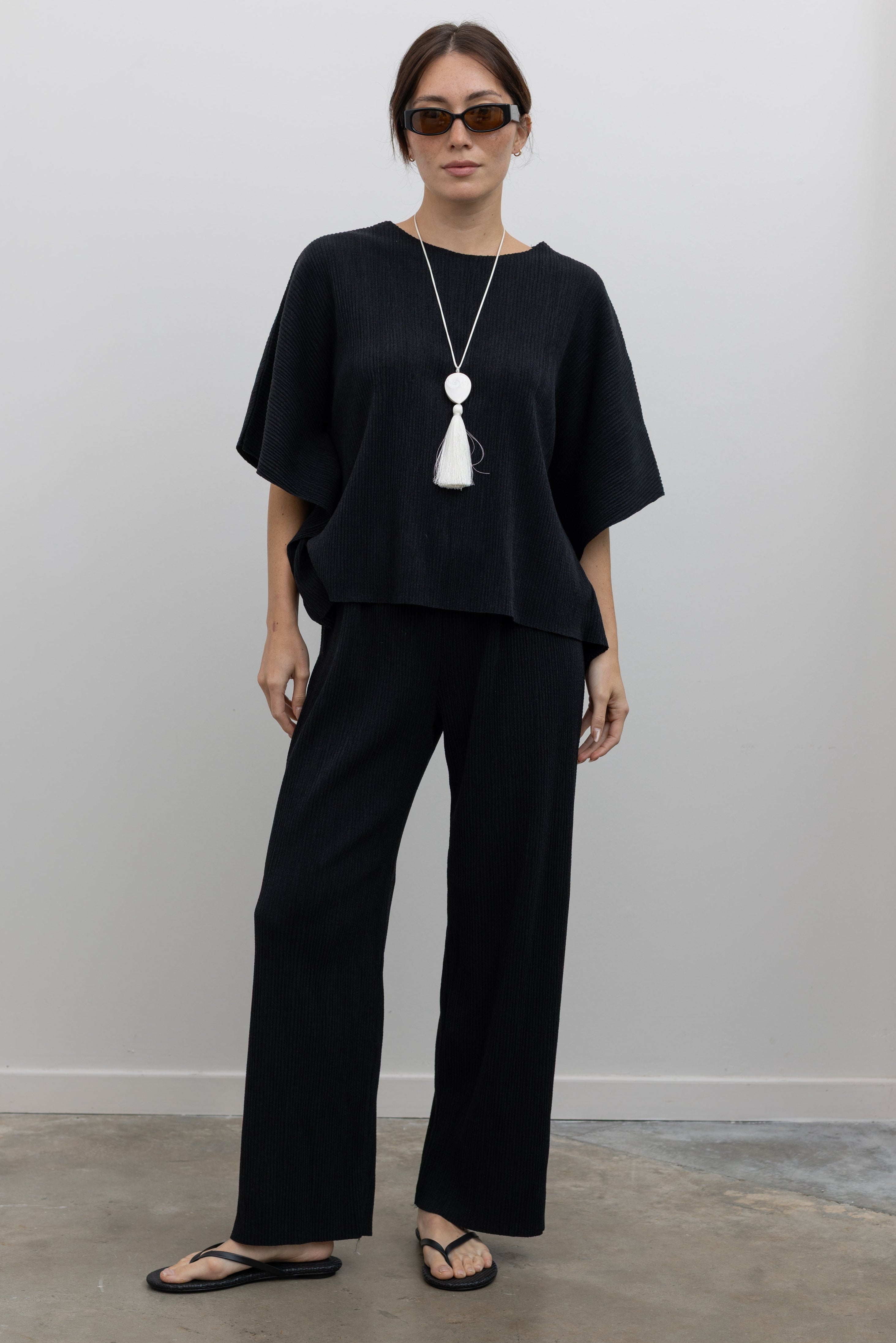 Collective plissé pleated straight-leg pants with fluid silhouette and elastic waistband at Alas Eius