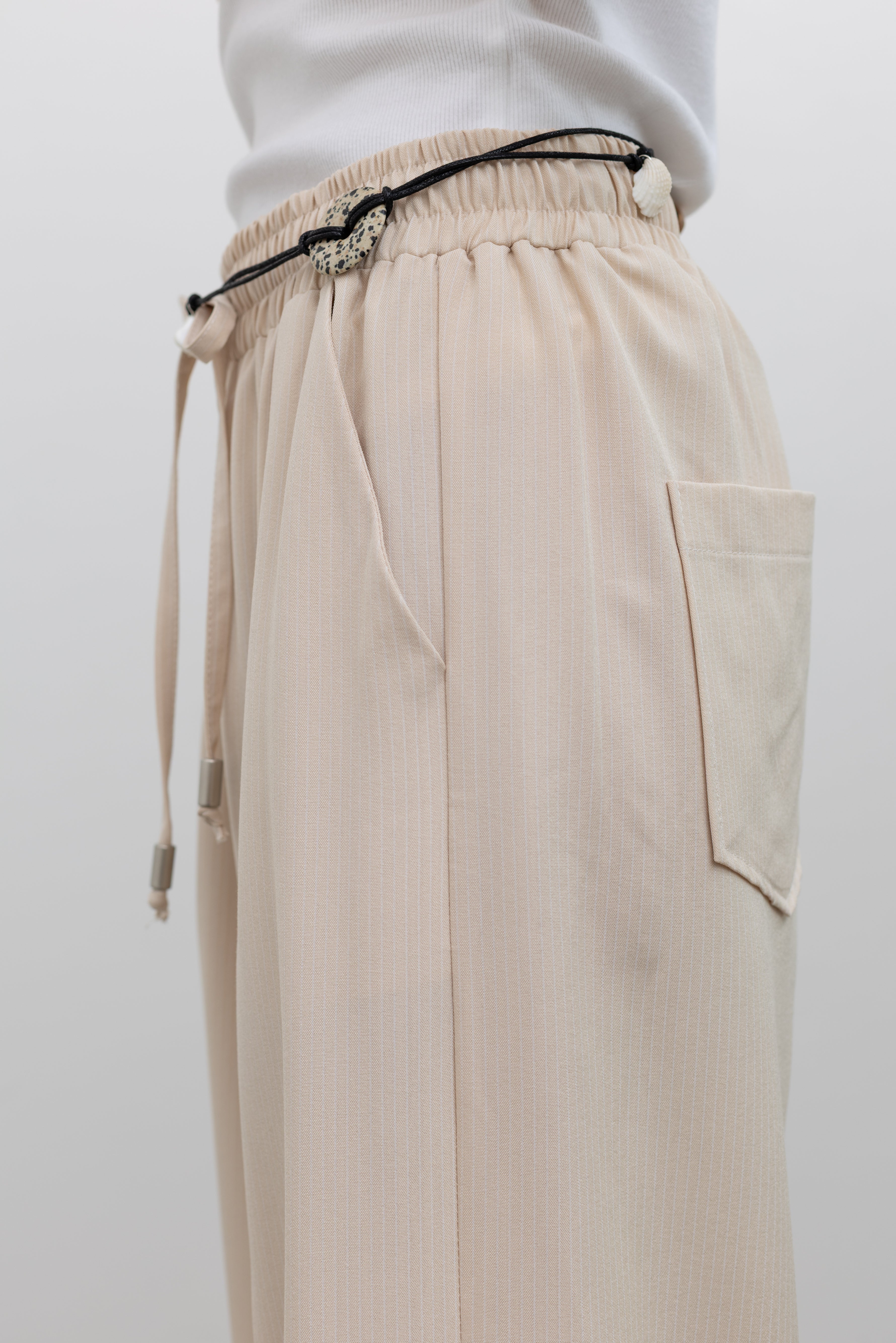 Collective pull-on pinstripe trousers with elastic waist and relaxed tailoring, ideal for women's elevated everyday and resort-inspired dressing at Alas Eius