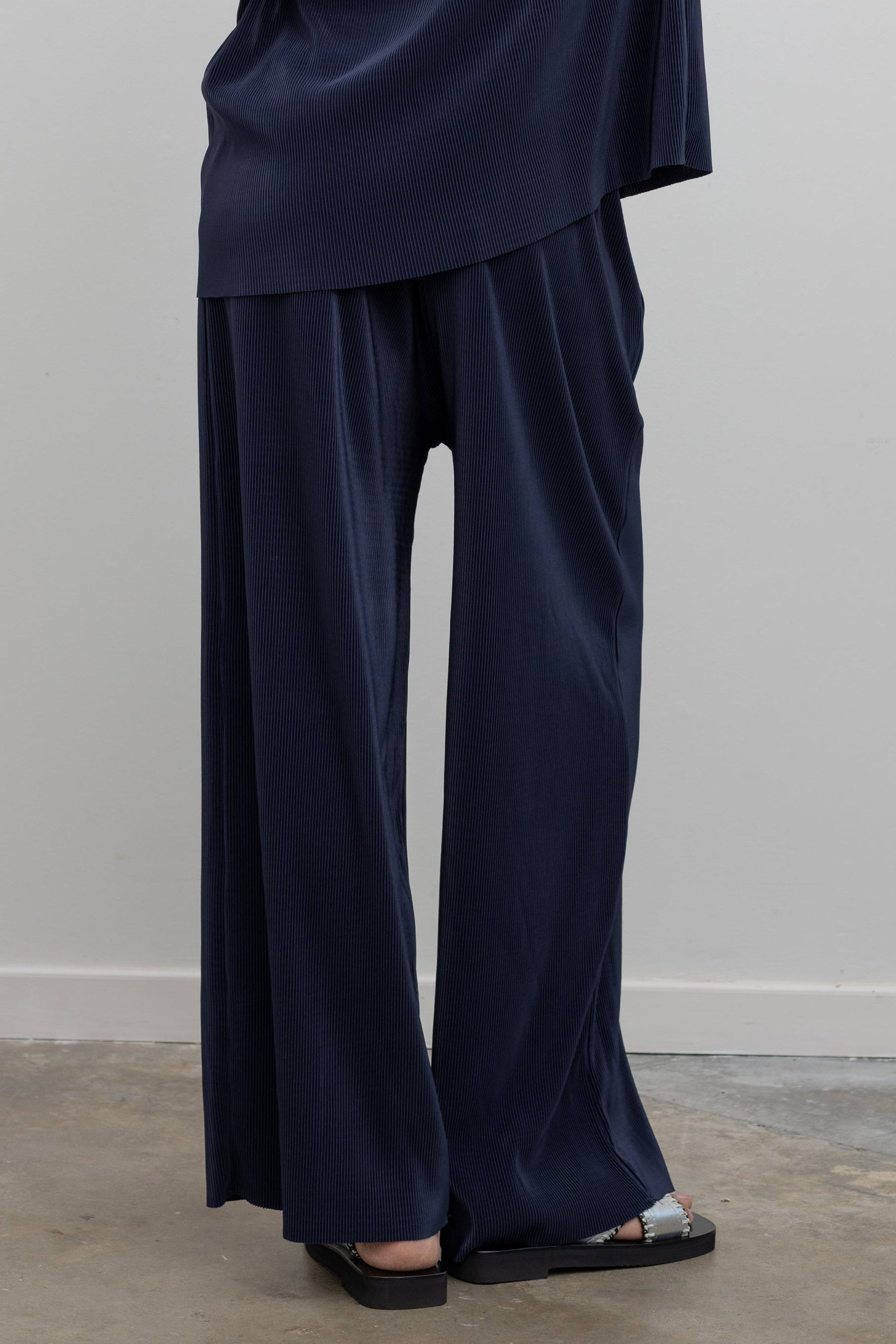 Collective relaxed navy pleated lounge pants with fluid drape at Alas Eius