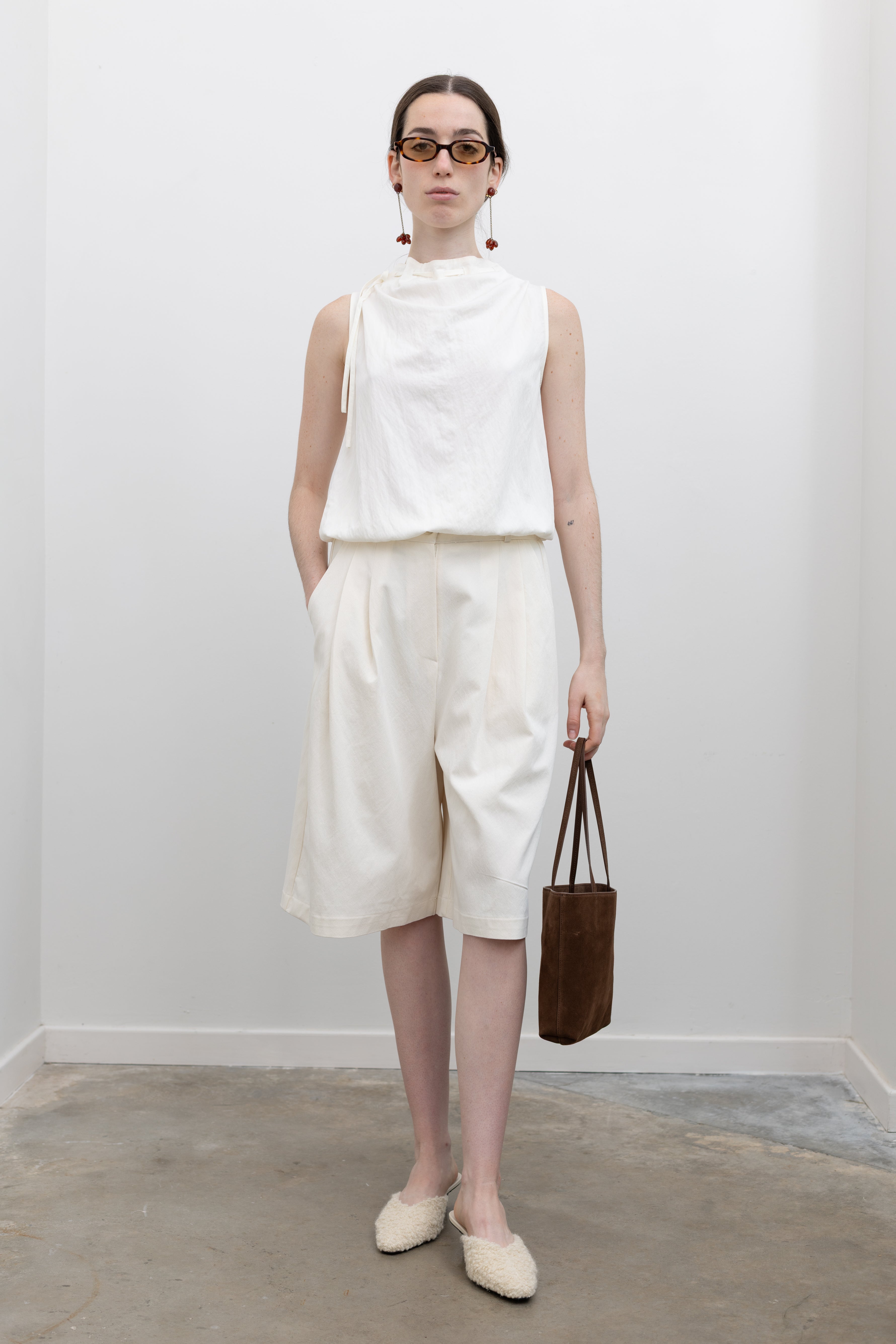 Collective sleeveless designer top with adjustable tie neckline and soft structured bubble hem for contemporary women's fashion at Alas Eius