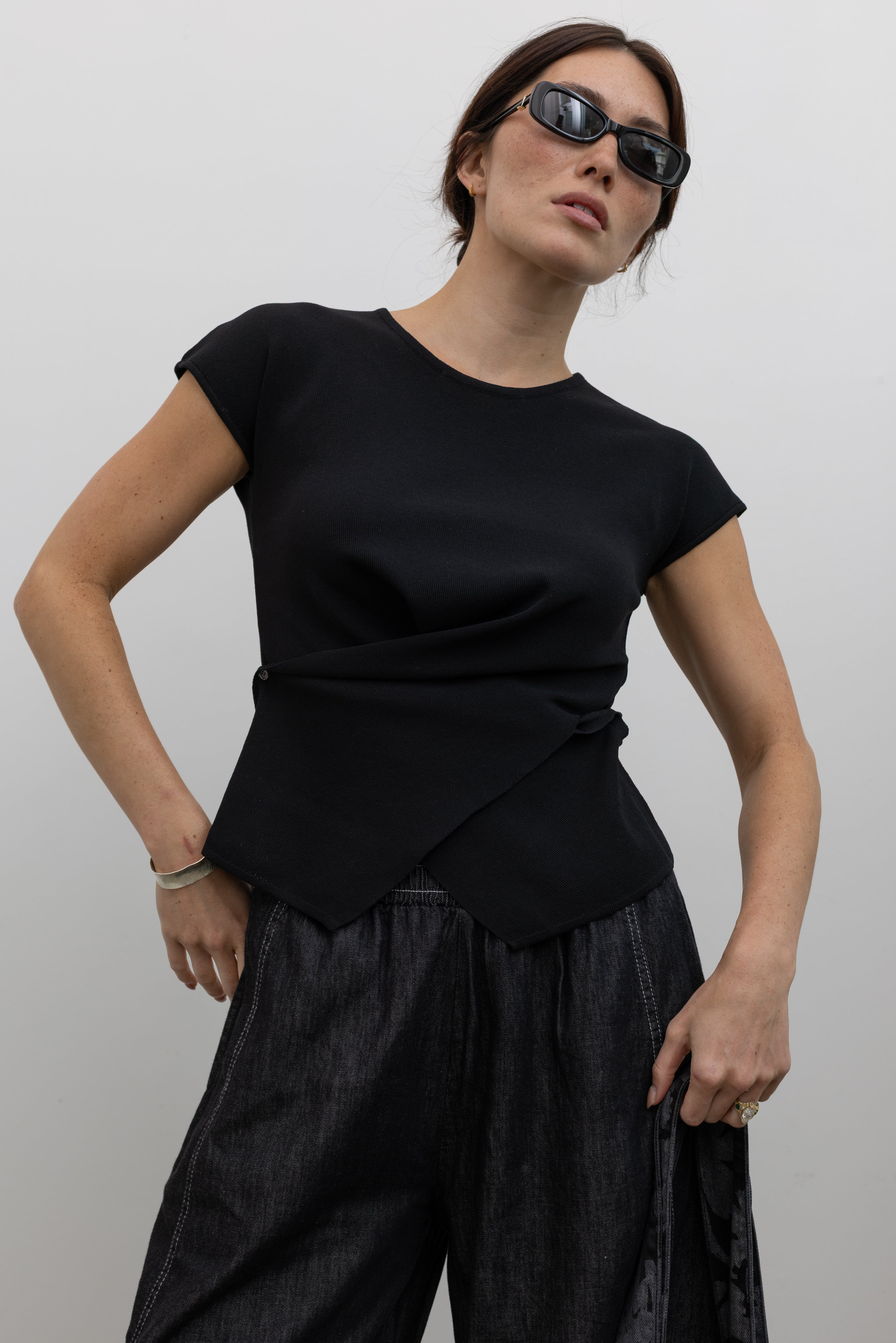 Collective soft acrylic wrap knit top with an overlapping button-front design at Alas Eius