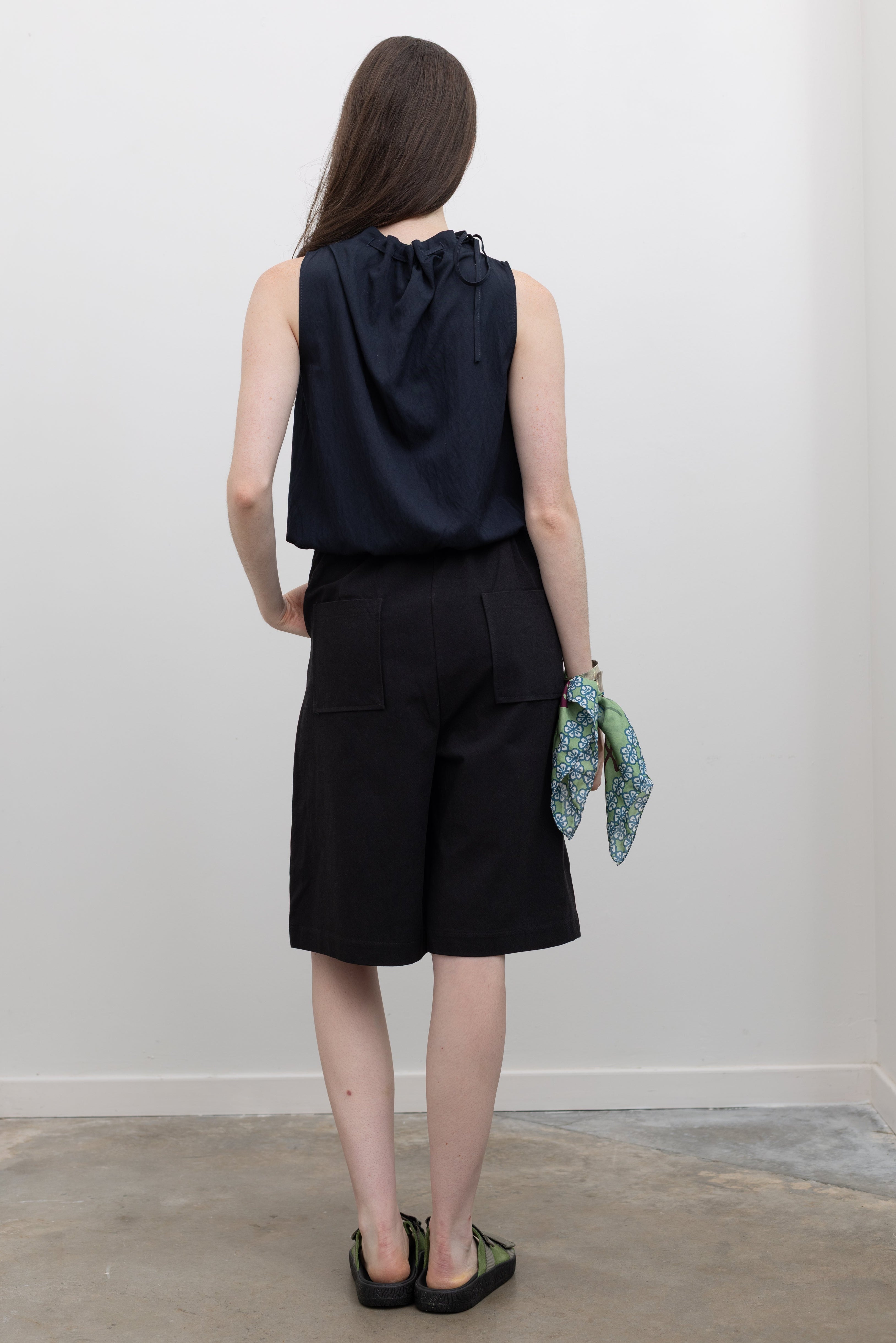 Collective tailored bermuda shorts with clean lines, front pleats, and a polished contemporary look at Alas Eius.