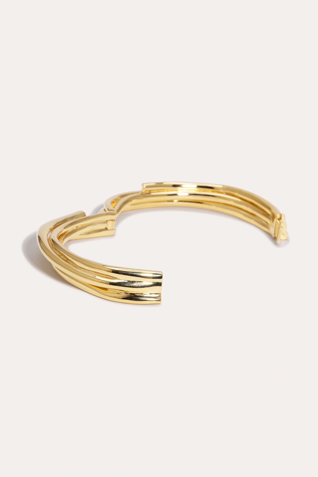 Completed Works handcrafted 18ct yellow gold plated brass bangle featuring a bold contemporary wrap design at Alas Eius