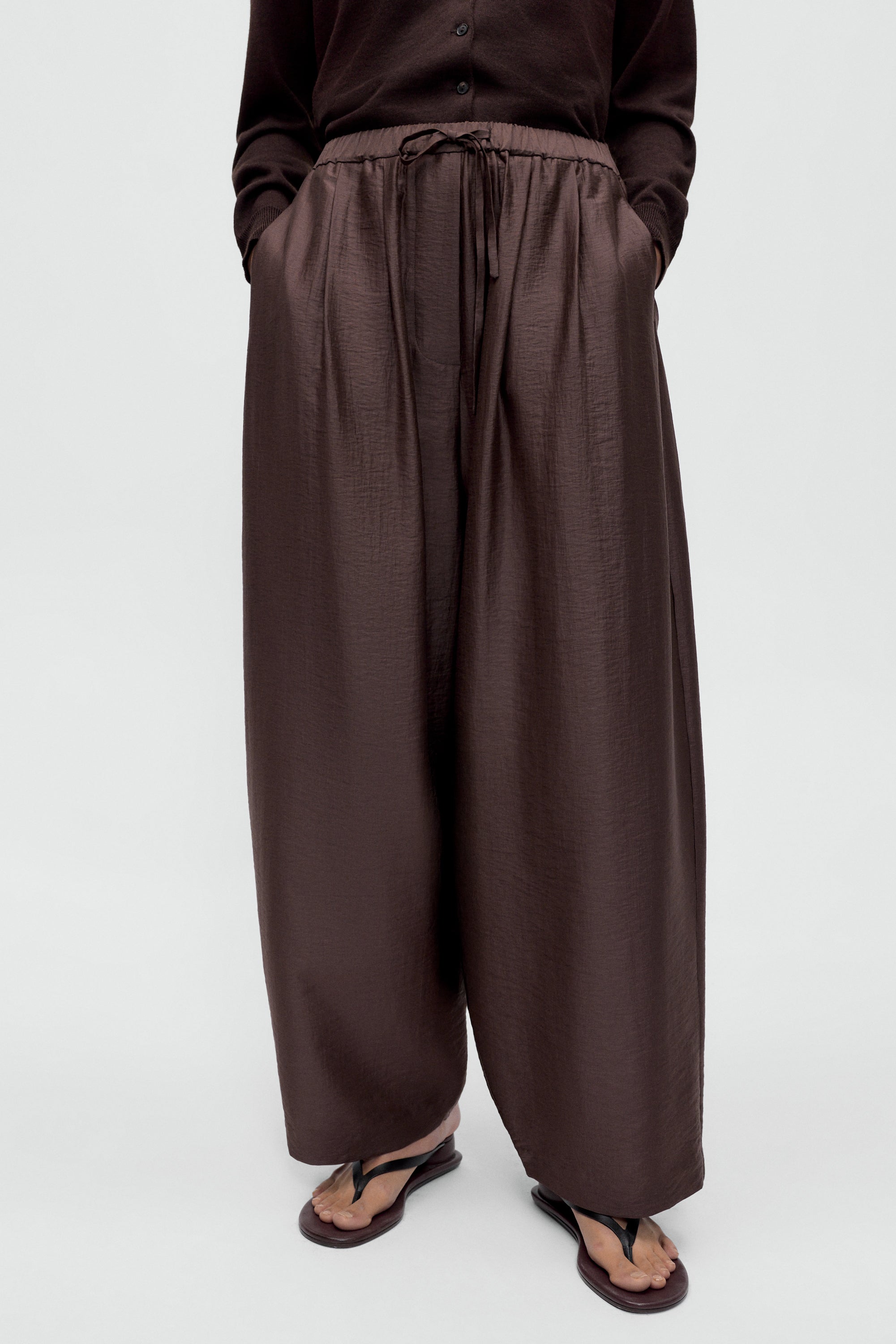Cordera flowing black maxi pants with relaxed fit and drawstring waistband at Alas Eius