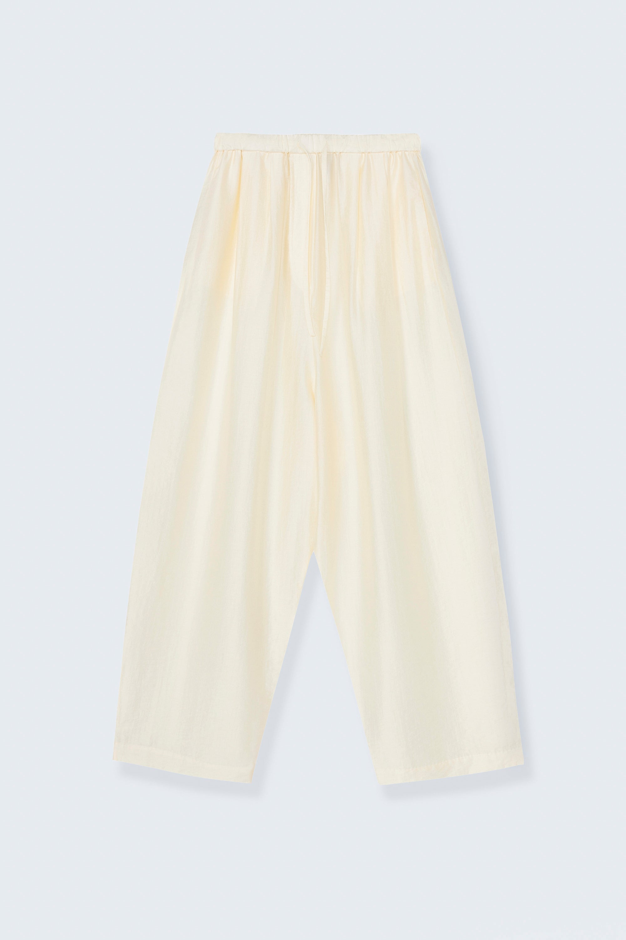 Cordera SS26 Marfil maxi pants designed with a fluid silhouette and a relaxed baggy fit. They feature a drawstring elastic waistband and side pockets at an Alas Eius store. 