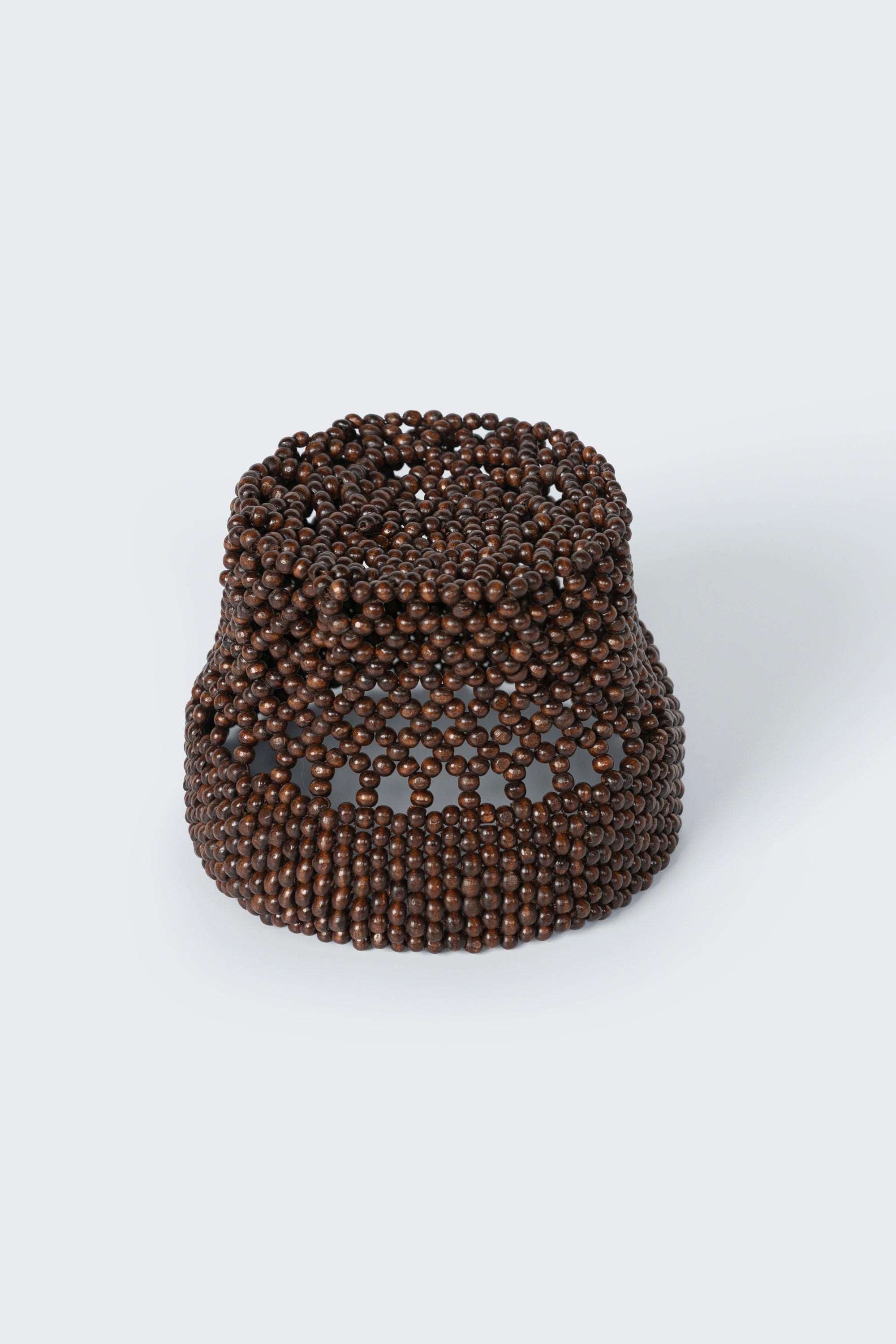 Cordera brown wooden bead bucket hat that is adorned with intricate hand-beaded wood beads, made with elastic threads to fit comfortably on the head at Alas Eius.