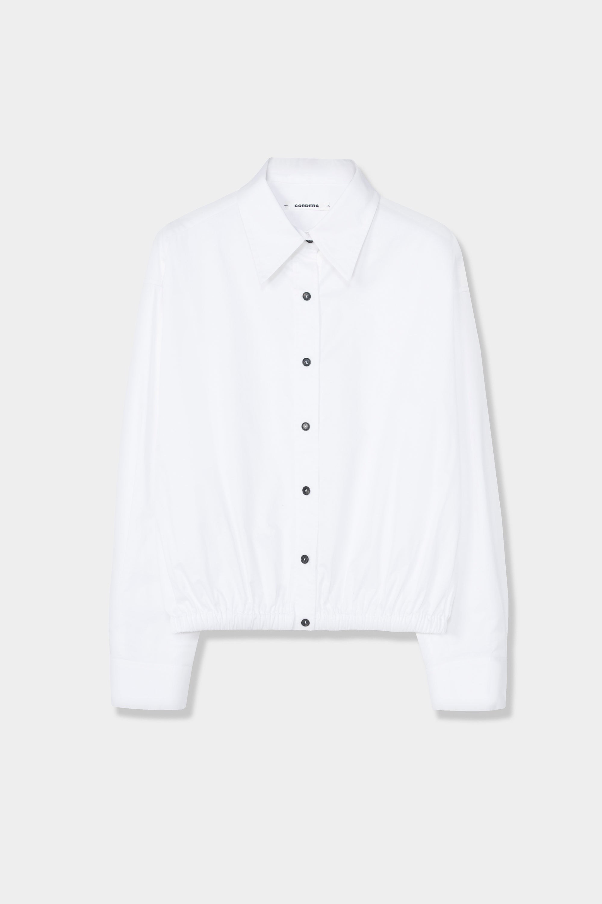 Cordera minimalist white balloon silhouette shirt with contrast buttons at Alas Eius