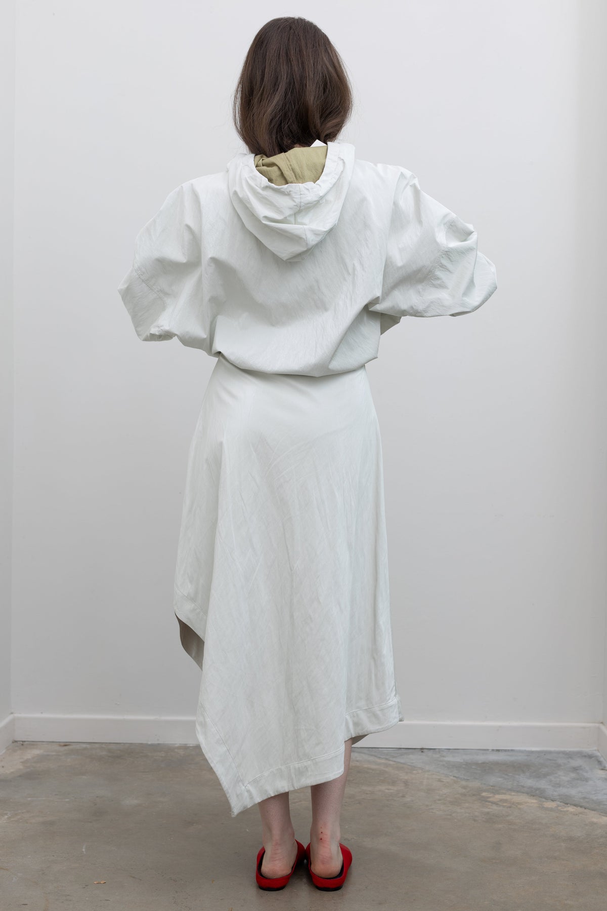 Nomia Optic White Asymmetric Midi Skirt with Front Pleat and Draped Volume, at Alas Eius