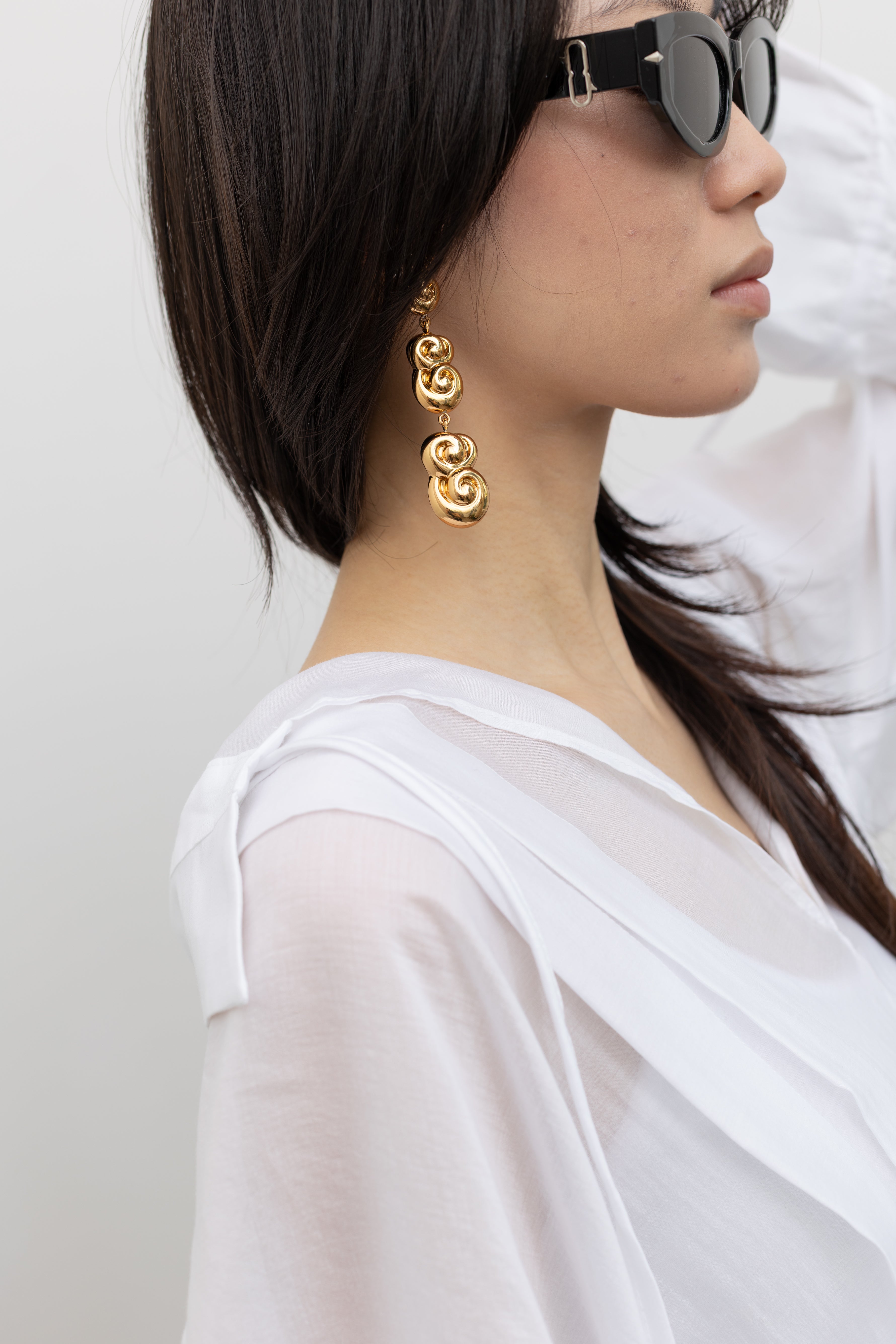 Rachel Comey old gold drop earrings with sculptural articulated links, styled as modern women's statement jewelry with lightweight elegance at Alas Eius