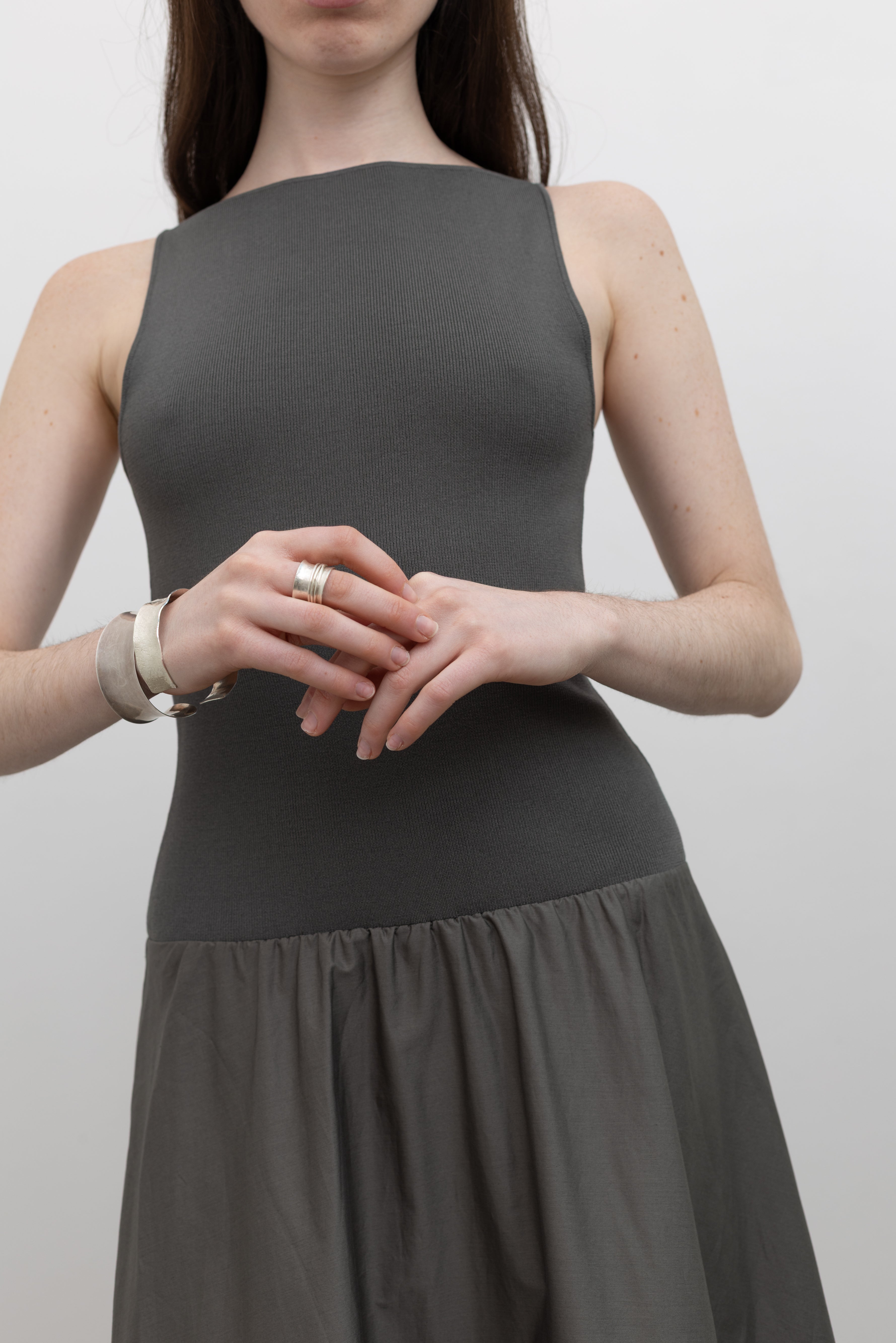 St. Agni minimalist black dress with an open back, structured knit bodice, and full-length skirt at Alas Eius.