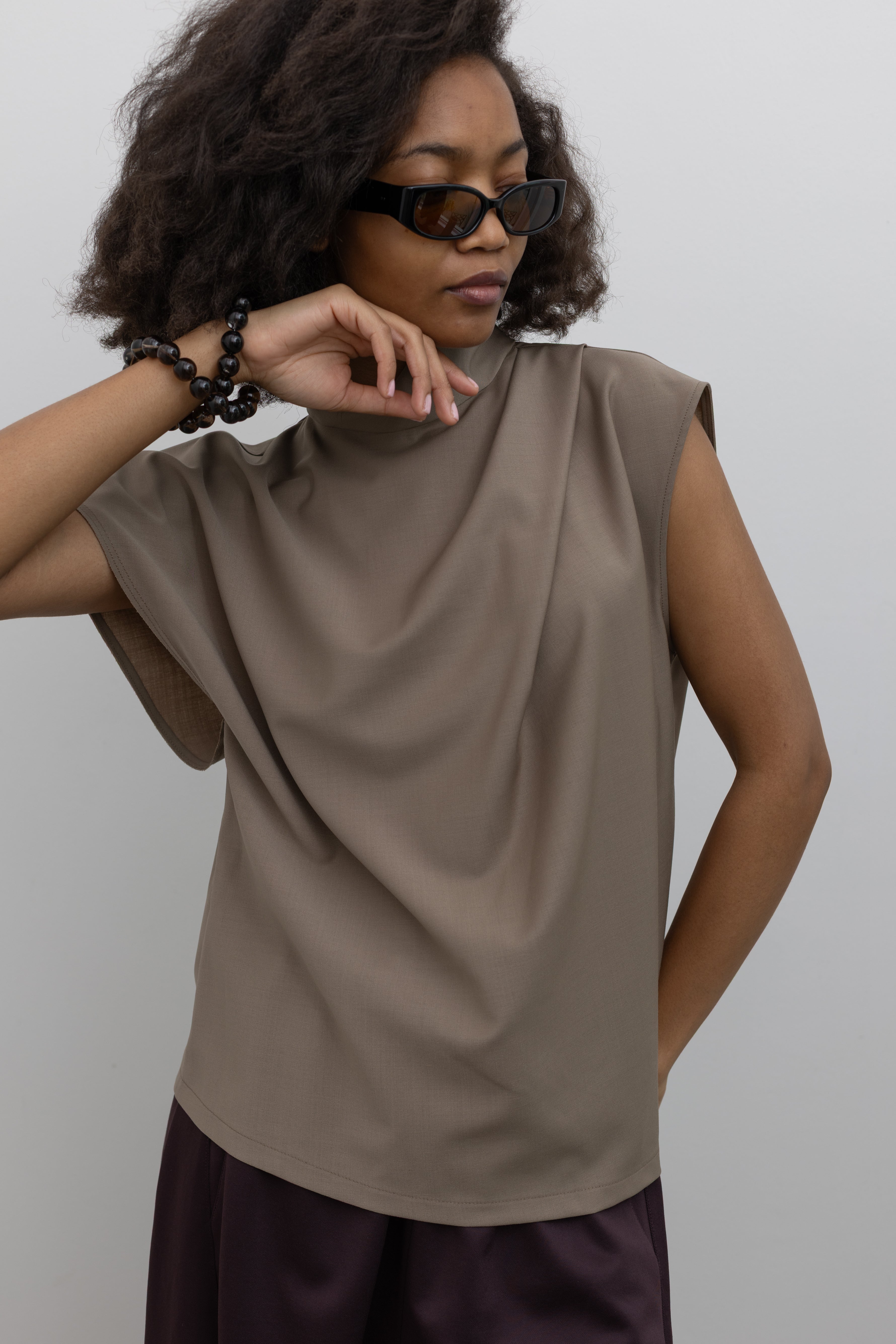 Tela Made in Italy wool-blend top with sculptural draping, asymmetrical sleeves, and an elegant high neck at alas eius.