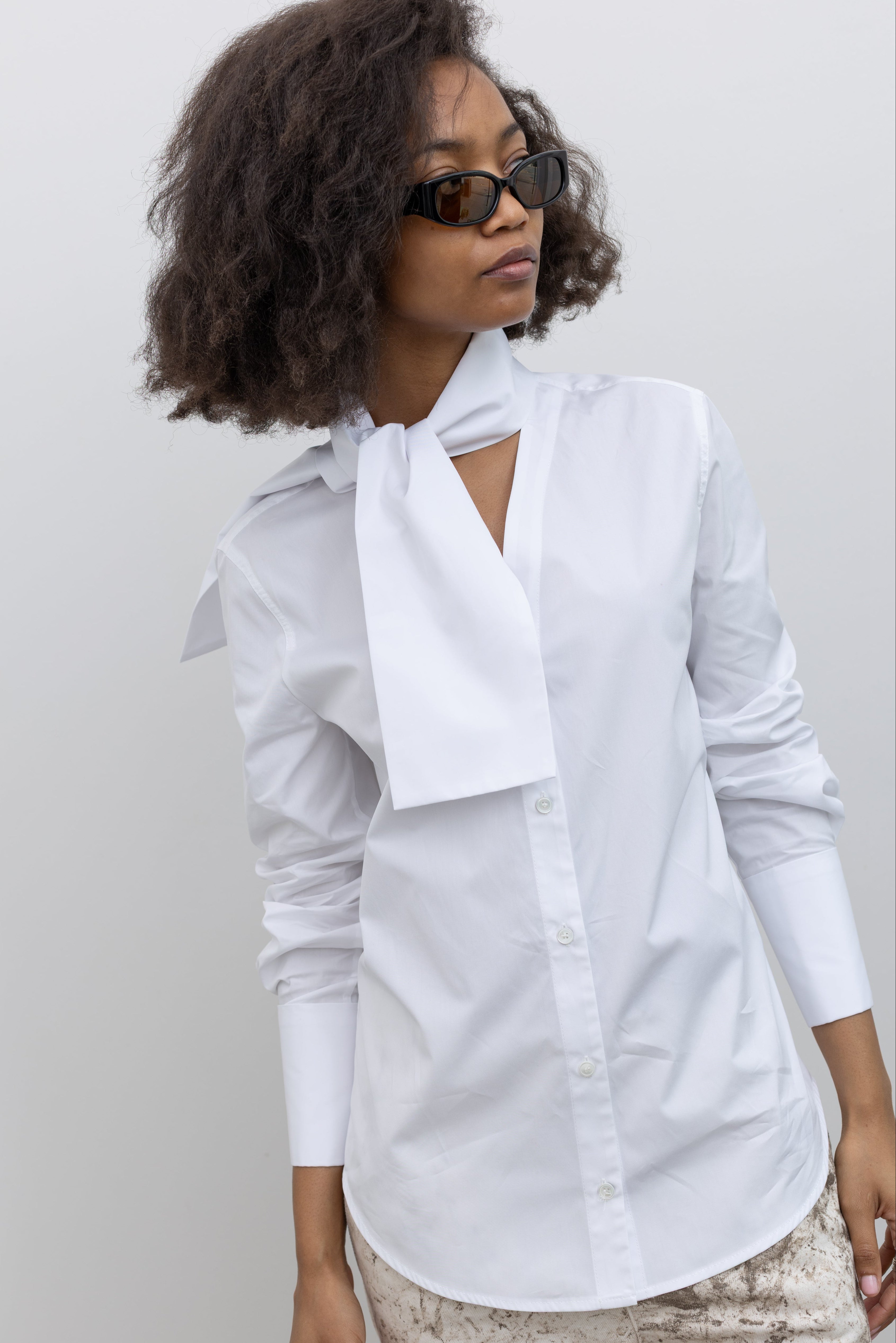 Tela Deanna classic white shirt reimagined with wide cuffs and a refined ascot-style neck tie at alas eius.
