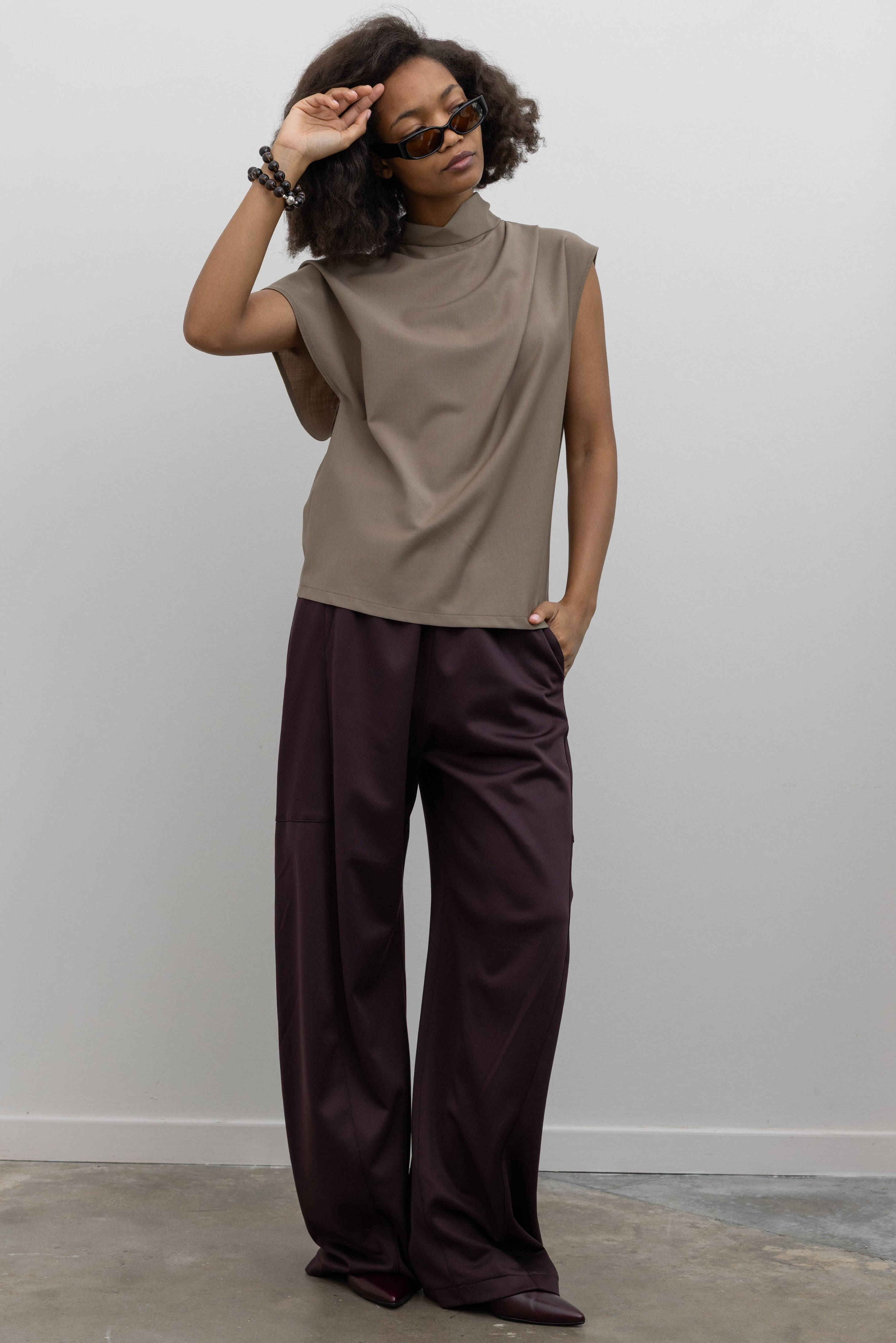 Tela Italian-made wool-blend top designed with architectural draping and an asymmetrical sleeve detail at alas eius.