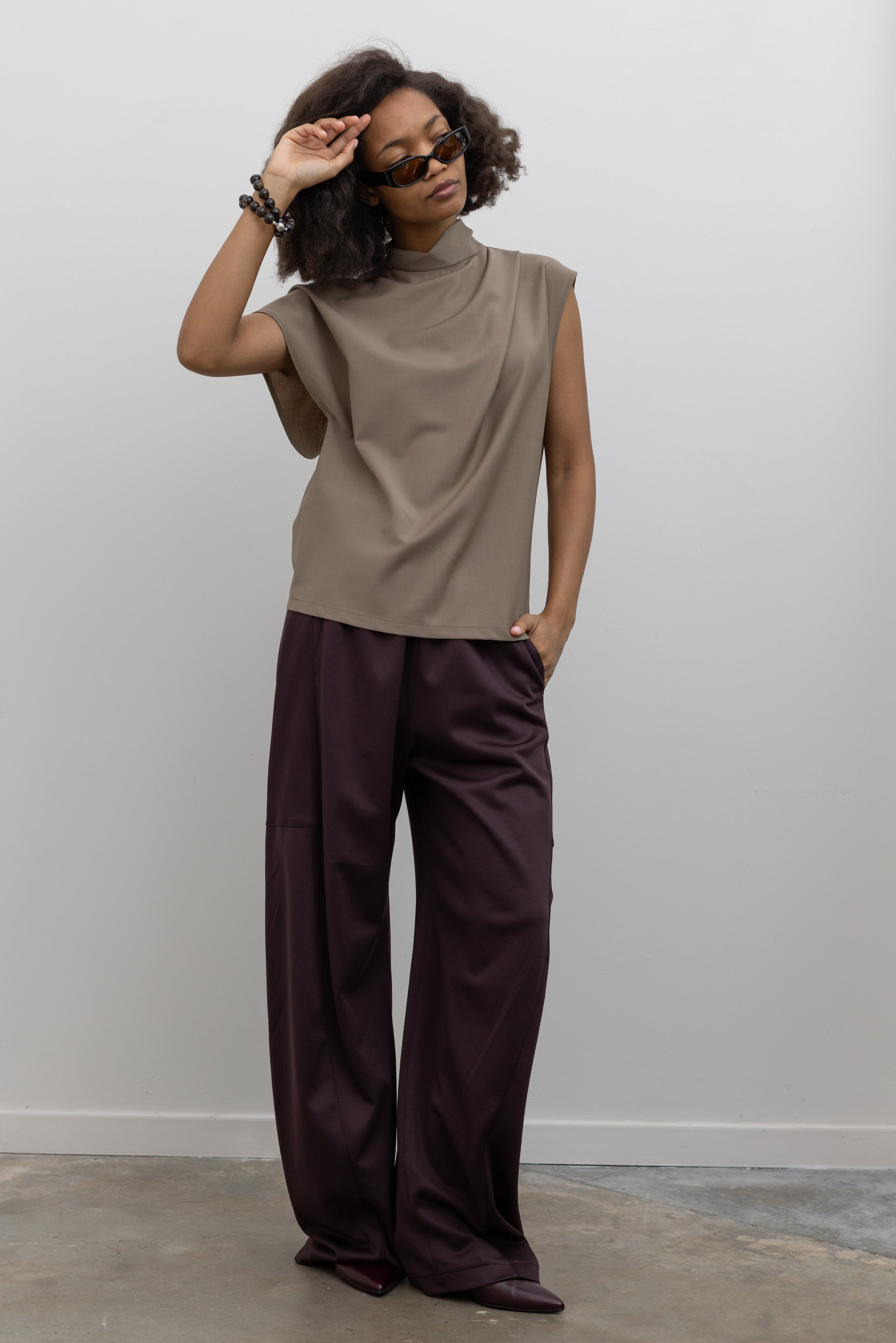 Tela Italian-made wool-blend top designed with architectural draping and an asymmetrical sleeve detail at alas eius.