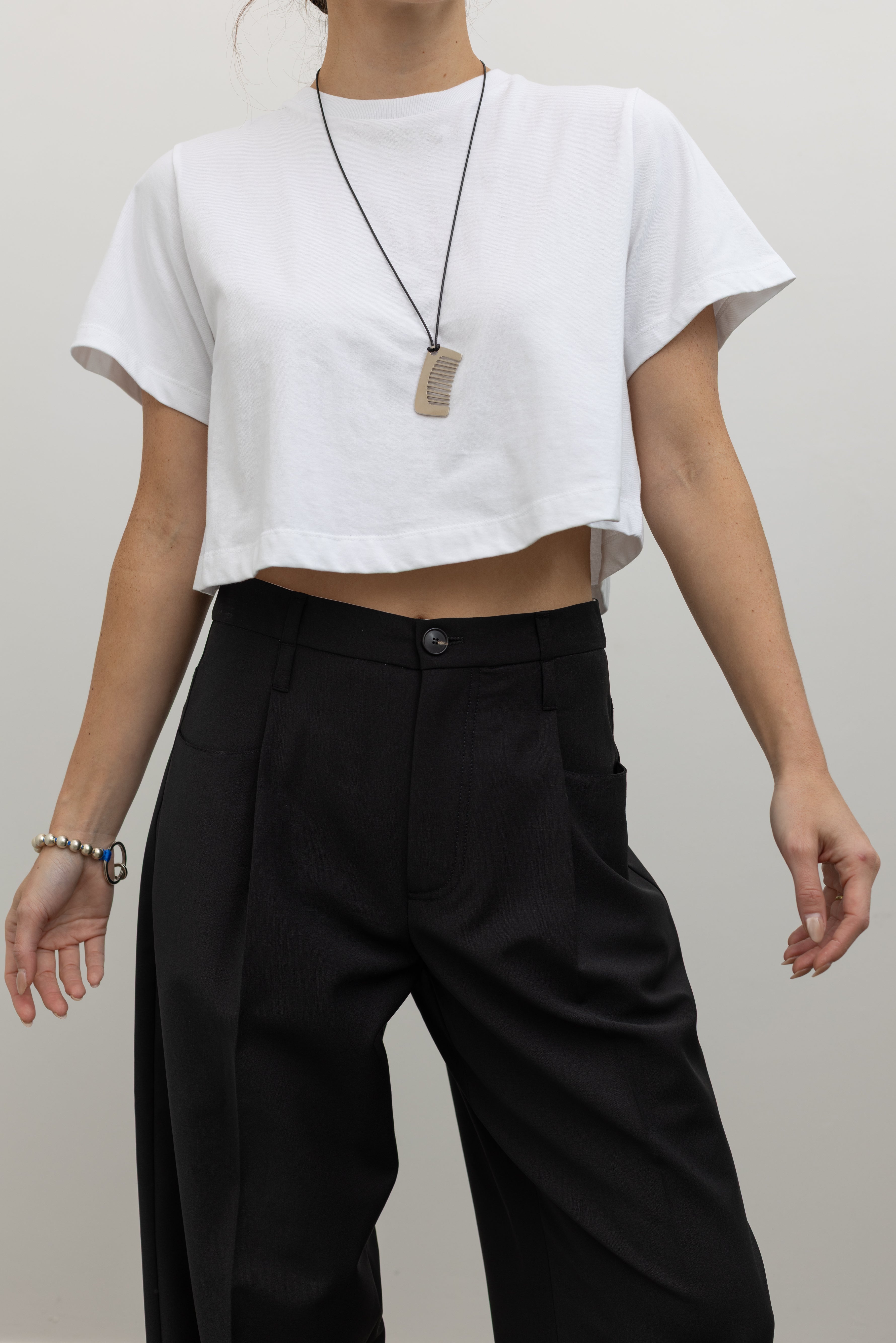 Tela tailored black trousers crafted in Italy with elegant pleating and a fluid straight-leg fit at alas eius.
