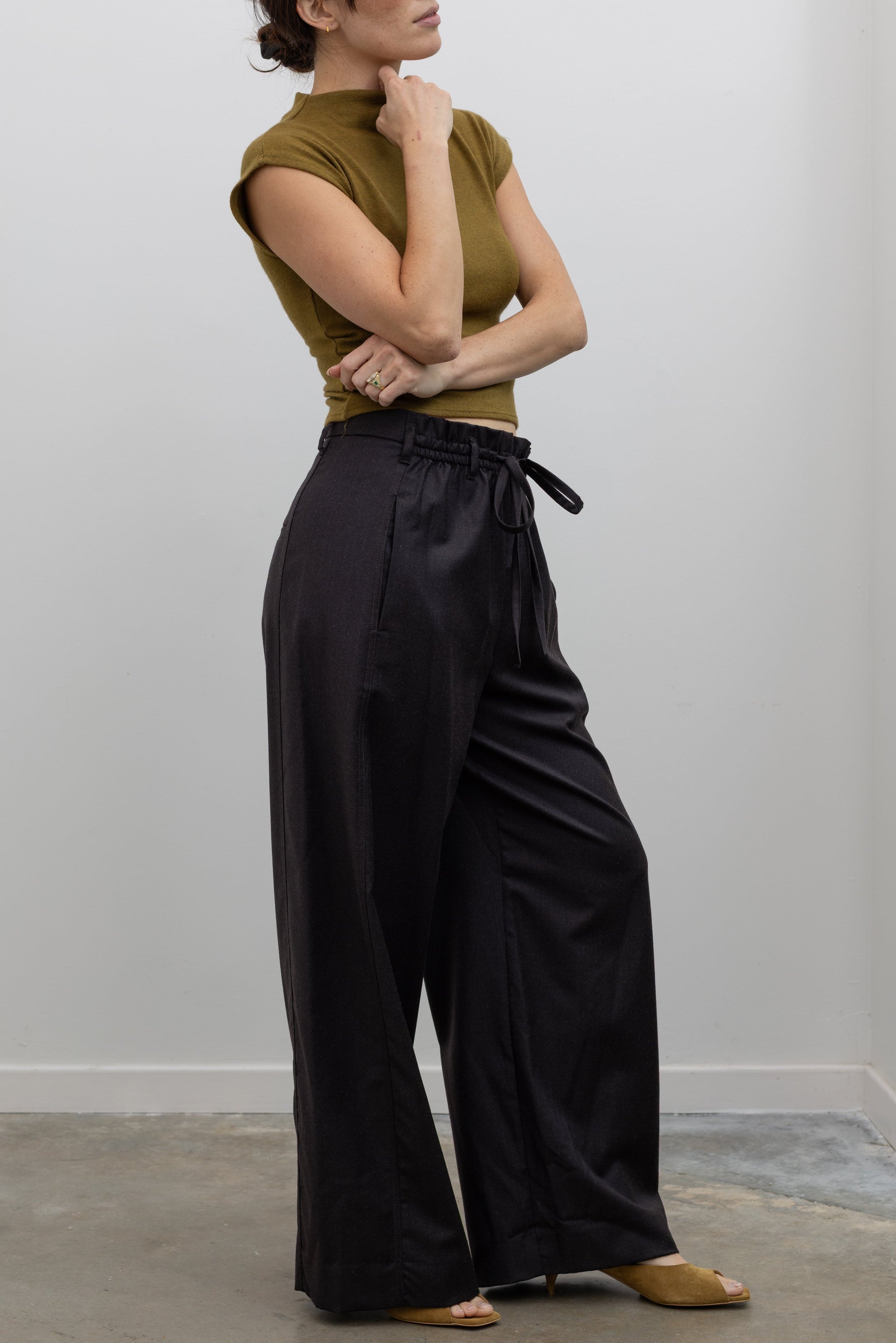 Tela Lucio dark brown pant with elegant drape, side pockets, and relaxed wide-leg fit at alas eius.