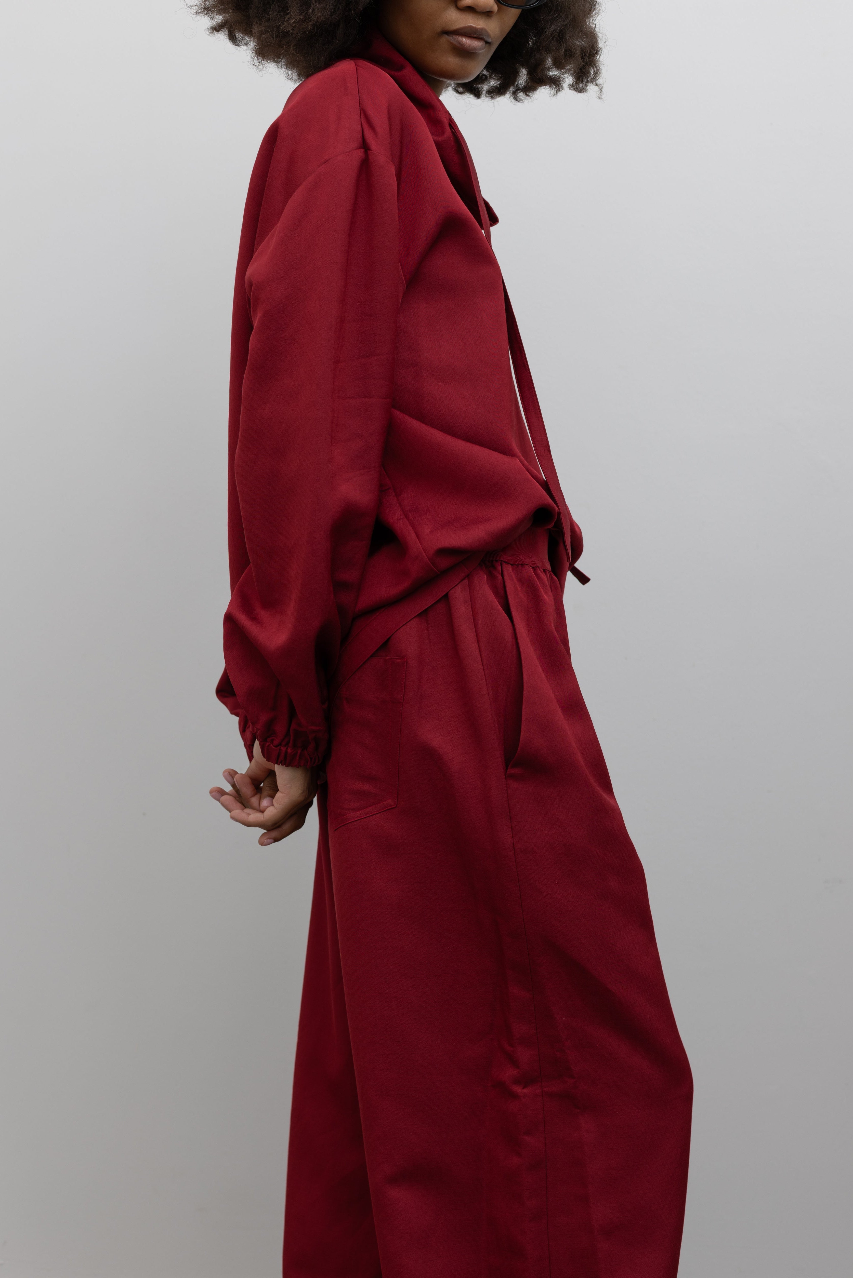 Tela Quota textured cherry red pant featuring a relaxed silhouette, comfortable elastic waist, and pockets at alas eius.