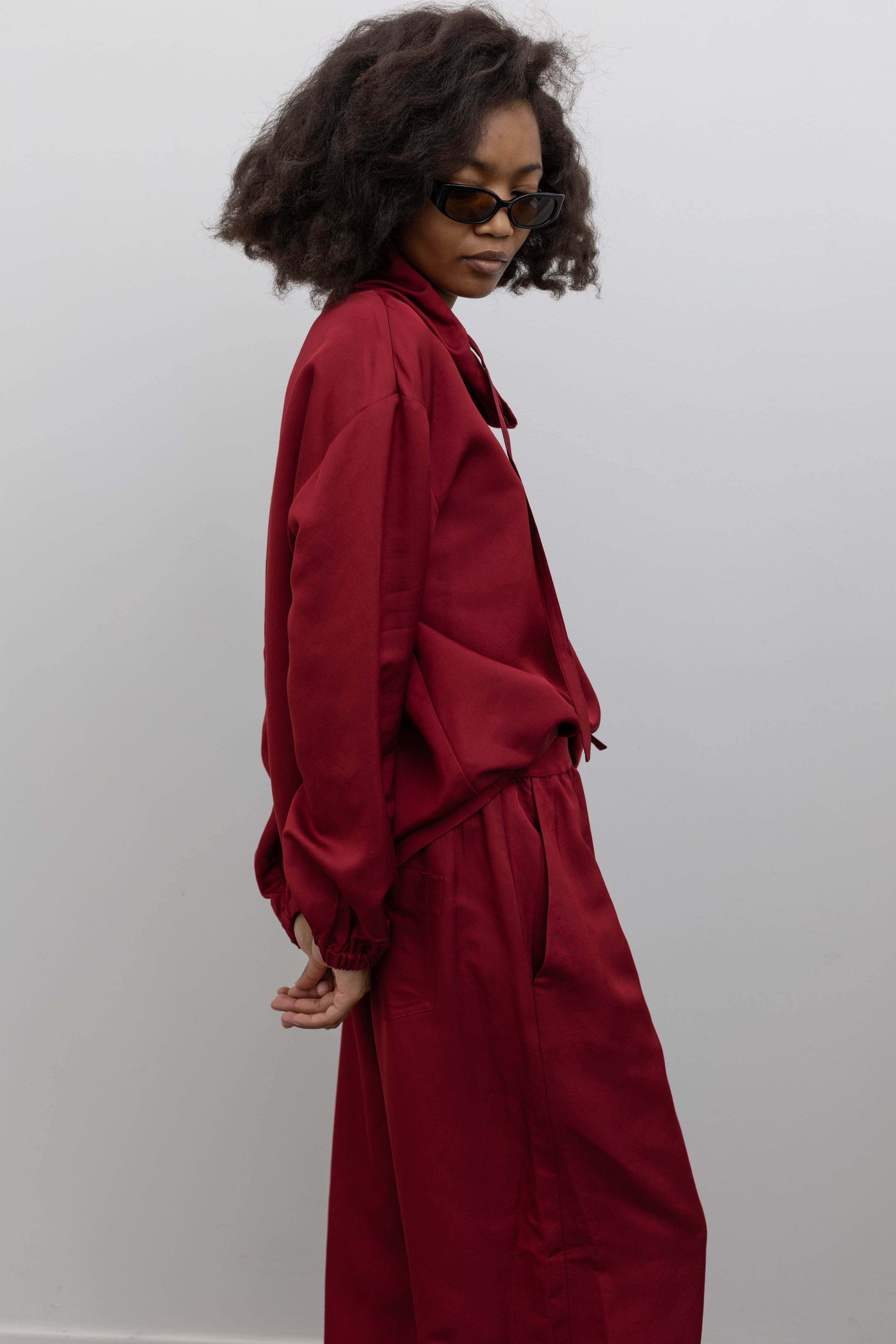 Tela relaxed cherry red sweatshirt with gathered cuffs, drawstring neckline, and textured finish at alas eius.