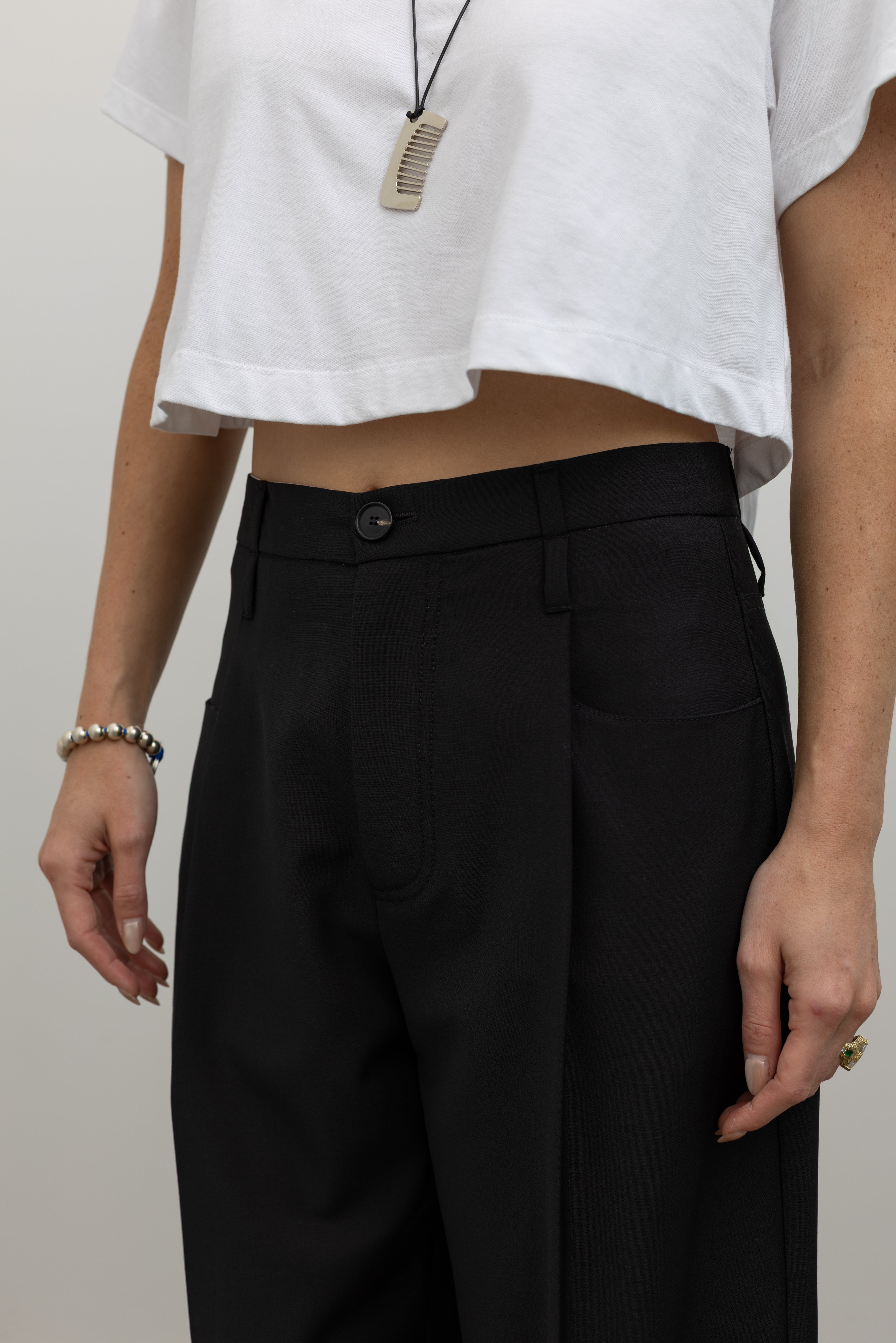 Tela black pleated trousers with a refined drape and timeless tailored design at alas eius.