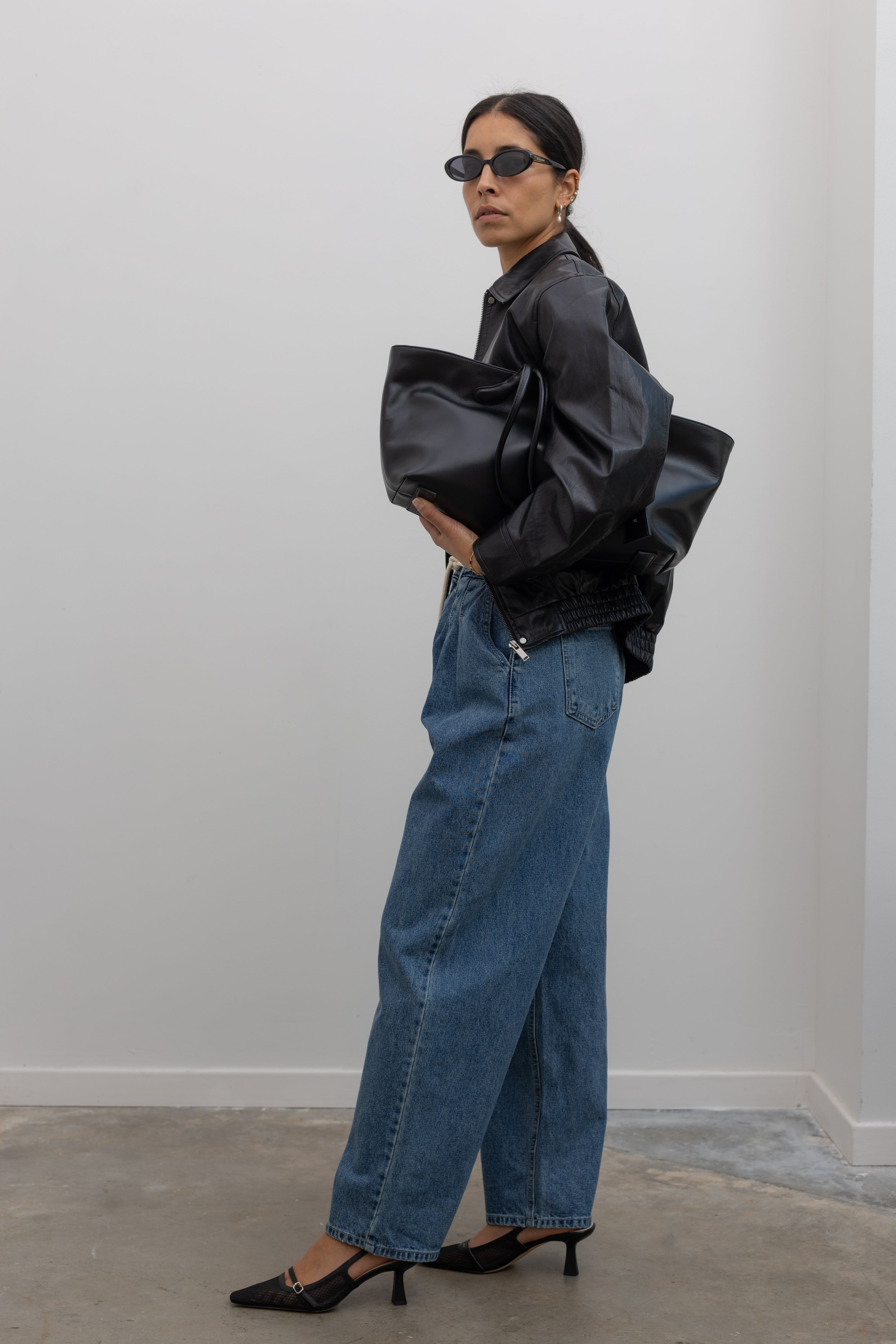 fall fashion with black leather jacket, baggy jeans and heels at alas eius